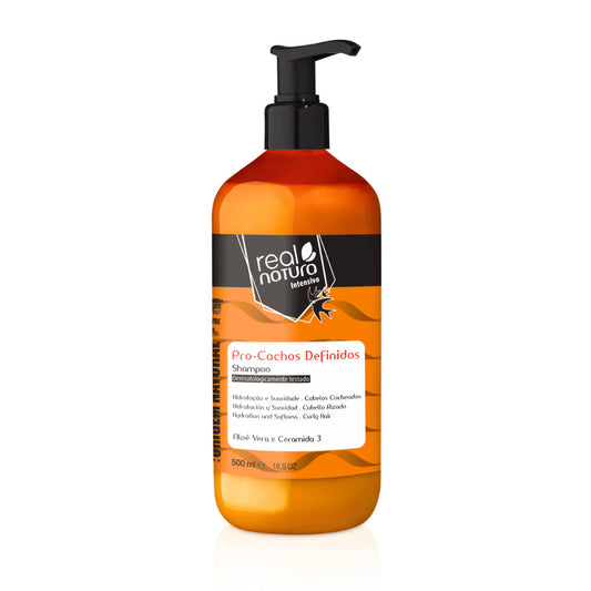 Shampoo Real Natura Pro-Cachos Definidos 500mL, frasco laranja e pump preto. Com Aloe Vera e Ceramida 3, promove hidratação e suavidade para cabelos cacheados.